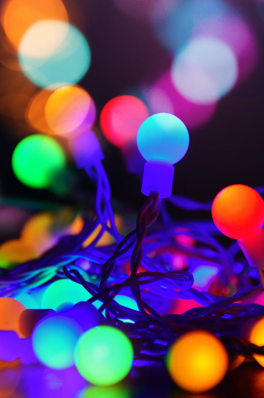 colored christmas lights on a string blurred with opaque colored shapes. Caption reads to understand how events and people string together you must develop a contemplative spirit.
